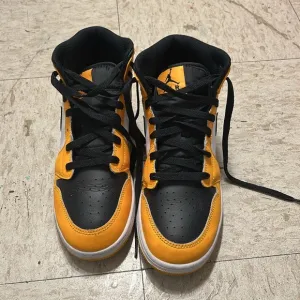 Black and yellow high top shoes